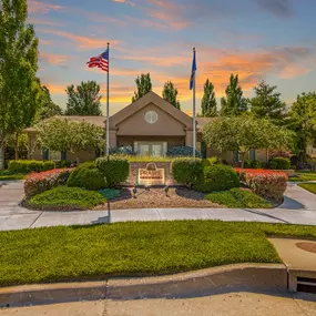 A house with a flag on top of it is surrounded by trees and bushes.