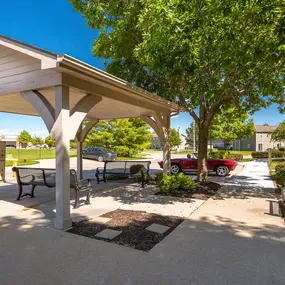 A covered outdoor seating area with a mailbox and a tree.