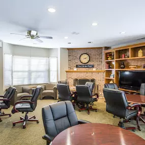 A conference room with a long table surrounded by chairs.