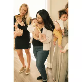 New moms standing together cuddling their infants