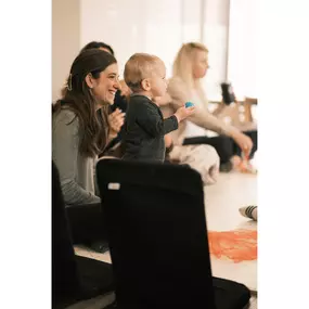 A new mom watches her infant smile and play in new mom classes