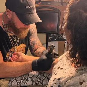 A tattoo artist in a black 