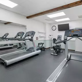 The fitness center, featuring treadmills, a bicycle, and free weights at Parkway International Resort.
