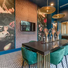 Unique community space with bold wall art, pendant lighting, and velvet chairs in Charlotte apartments