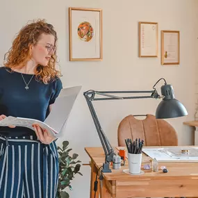 Webstudio Dresden Portraitaufnahme am Schreibtisch mit Unterlagen, natürliche Ausstrahlung und freundliches Lächeln.