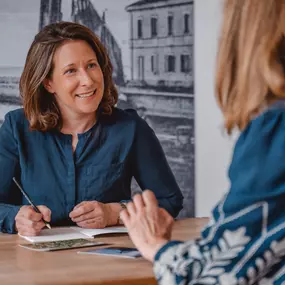 Webstudio Dresden Beratungssituation am Tisch, offene Kommunikation mit Notizen, Fokus auf persönliche und individuelle Betreuung.