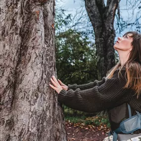 Webstudio Dresden Authentisches Outdoor Foto mit Frau an Baum, Fokus auf Naturverbundenheit und Achtsamkeit, inspirierender Moment.