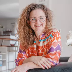 Webstudio Dresden Fröhliches Portrait einer Frau mit Locken und Brille, natürliche Ausstrahlung und positive Stimmung.