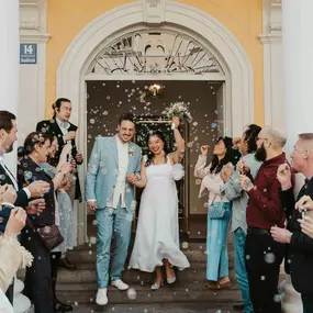 Kara Elizabeth Photography Brautpaar verlässt das Standesamt in München, umgeben von Gästen und Seifenblasen. Authentische Hochzeitsfotografie voller Freude.