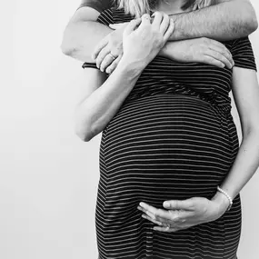 Kara Elizabeth Photography Künstlerisches Schwangerschaftsfoto in München – Nahaufnahme des Babybauchs in Schwarz-Weiß mit emotionaler Atmosphäre.