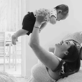 Kara Elizabeth Photography Babyshooting in München – Mutter hebt ihr Baby lachend hoch. Authentische Familienfotografie voller Nähe und Freude.