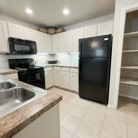 Kitchen with white cabinets and black appliances