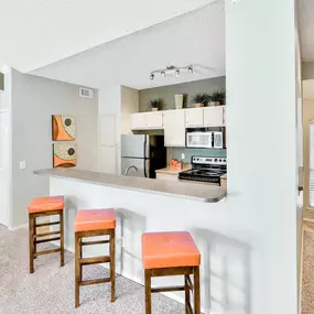Interior kitchen view with kitchen countertop and orange seating