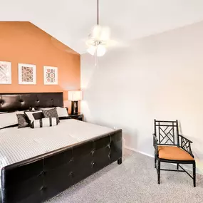 Spacious bedroom with orange accent wall