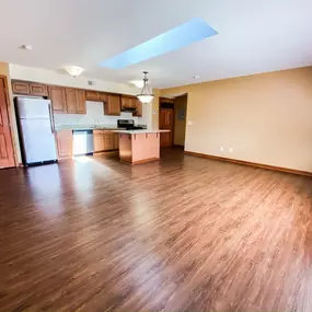 An empty living room and kitchen with wood flooring