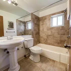 A bathroom with a toilet and a sink and a bath tub
