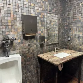 Clean tiled restroom with granite sink and modern fixtures inside Bucharest Grill in Detroit, Michigan