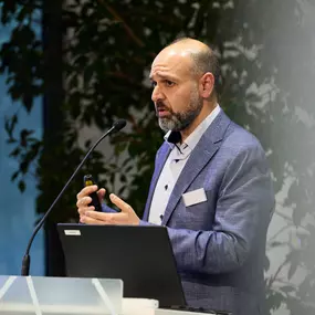 Foto und Filmproduktion Laila Tkotz Vortrag mit Laptop und Präsentation in moderner Konferenzumgebung