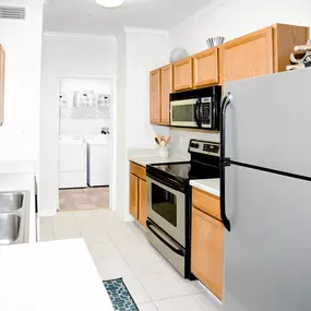 Modern kitchen with a stainless steel refrigerator, microwave, and oven