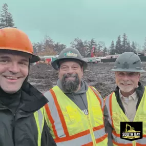 Aaron Hosmer Shawn Dean South Bay Grading Photo of three South Bay Grading (SBG) executives on an active grading and excavation job site. They are wearing hard hats and high‑visibility safety vests, standing in front of heavy equipment and soil piles on an overcast day. The SBG logo appears in the bottom‑right corner. Location: South Bay/Silicon Valley, California.