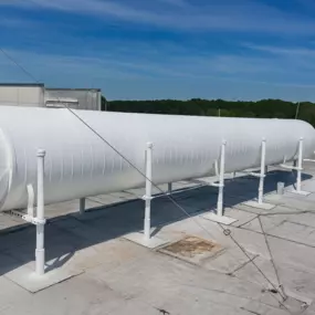 Industrial pipe freshly painted with protective coating on a commercial rooftop.