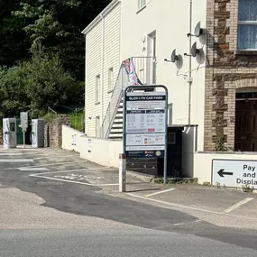 The entrance to Glen Lyn Car Park with prominent parking signage displaying hourly rates and terms, alongside InstaVolt ultra rapid chargers visible in the background, clearly marked bays and directional signage.