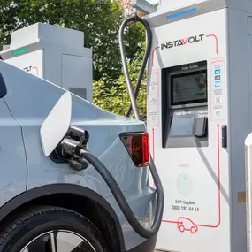 Detailed view of an EV connected to an InstaVolt charger at Country House Estates, showing the screen and payment terminal.