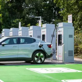 Polestar 2 charging at an InstaVolt station in Exeter with multiple chargers and green surroundings visible.