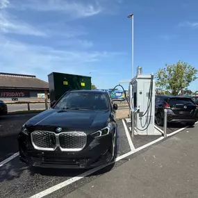 BMW and Nissan electric vehicles charging at InstaVolt ultra-rapid units in Thornaby's Teesside Retail Park with TGI Fridays visible nearby.
