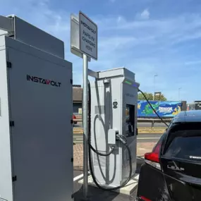 Nissan Leaf charging at InstaVolt ultra-rapid EV station in Stockton-on-Tees retail park with clear signage and modern infrastructure.