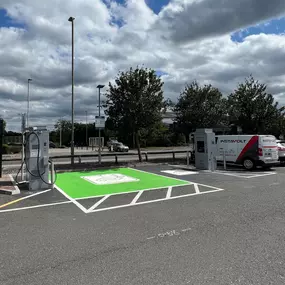 InstaVolt EV chargers with green-marked bays beside a McDonald’s, with an InstaVolt van parked nearby.