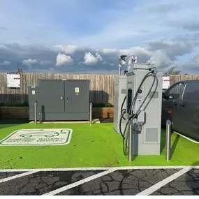 Close-up of an InstaVolt charger with a green-painted EV bay at The Gissons Hotel, Kennford. The bay is clearly marked for electric vehicle use.
