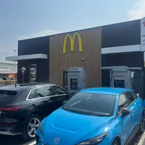 Two electric cars charging at InstaVolt ultra-rapid chargers outside a McDonald’s