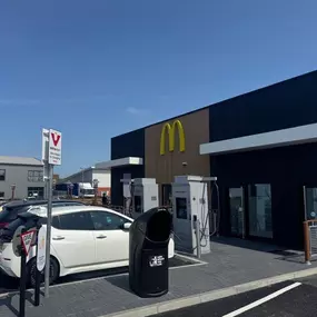 InstaVolt chargers positioned at the side of a McDonald’s with outdoor seating and a Tesco Express visible in the distance.