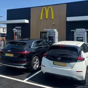 Electric cars using InstaVolt chargers outside a McDonald’s, with Tesco Express across the car park.