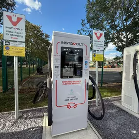 Front view of an InstaVolt ultra-rapid charger at Mile House, Stockton-On-Tees, with visible instructions and safety signage.