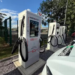 Side view of InstaVolt ultra-rapid chargers at Mile House with several units available for use.