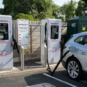 InstaVolt EV charging station at The Avenue Car Park, Blakedown, with a silver electric car plugged in and marked bay signage visible.