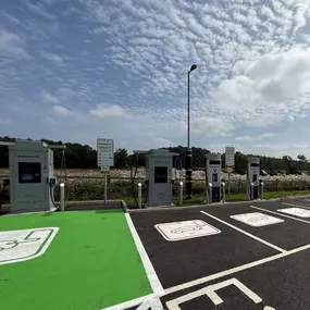 Modern InstaVolt EV chargers lined up at a convenient A64 location with open surroundings and ample signage, ideal for fast, accessible charging.