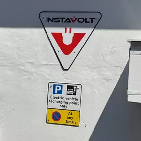 Wall signage showing the InstaVolt logo and a dedicated parking notice for electric vehicle charging only at Taw Esso, Barnstaple.