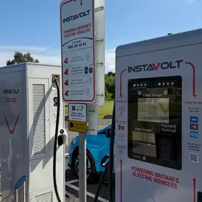 This image shows detailed instructions on how to use the InstaVolt EV charger, including the payment terminal, signage with step-by-step guidance, and clear brand messaging.