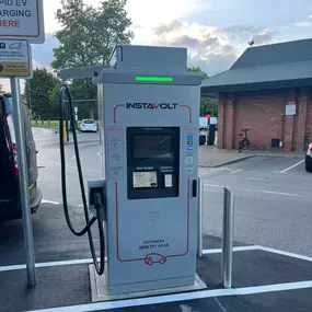 InstaVolt charger in an EV-only space at McDonald’s, with user-friendly screen and 24/7 helpline, offering fast, convenient charging near key roadside amenities.