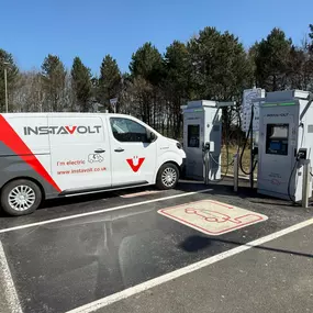 This side profile captures a busy InstaVolt charging site with several vehicles actively charging. The well-spaced units and accessible layout are designed for quick and convenient EV charging.