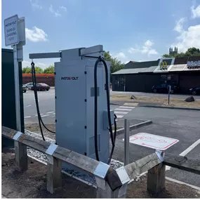 This photo captures the rear side of an InstaVolt rapid EV charger at Gallagher Retail Park. McDonald’s is visible directly opposite, and the charging unit is clearly marked with directional signage.