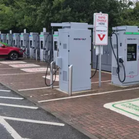 View of InstaVolt charging bays at Bodmin Retail Park, with EVs plugged in and clear signage visible.