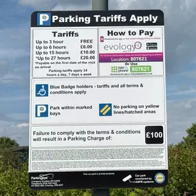 Clear signage showing parking tariffs and payment instructions, applicable to the InstaVolt charging bays at Three Trees Farm Shop in Swindon.