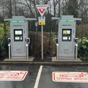 InstaVolt EV charging bays on a rainy day at OK Diner Leominster, with two chargers and branded parking