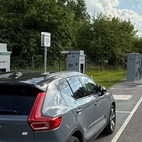 Set against lush greenery, a Volvo EV is seen from behind as it charges at one of InstaVolt’s ultra rapid units near Cobbs Farm Shop on Bath Road. The scene reflects peaceful surroundings and seamless charger layout for EV drivers.
