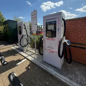 A clear view of InstaVolt’s ultra-rapid chargers installed at Sorbonne Close, Thornaby, showing accessible plug types and simple tap-to-pay functionality near a fenced area.