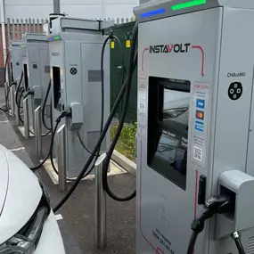 Close-up of InstaVolt ultra rapid chargers in use at Four Pools Retail Park, Evesham, with a vehicle plugged in and charging.